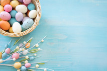 Basket of easter eggs on a blue wood background