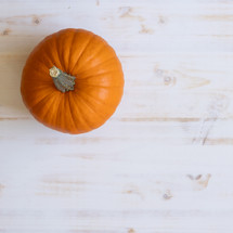 orange pumpkin on a white wood background 