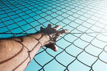 hand grabbing a metallic fence feeling freedom