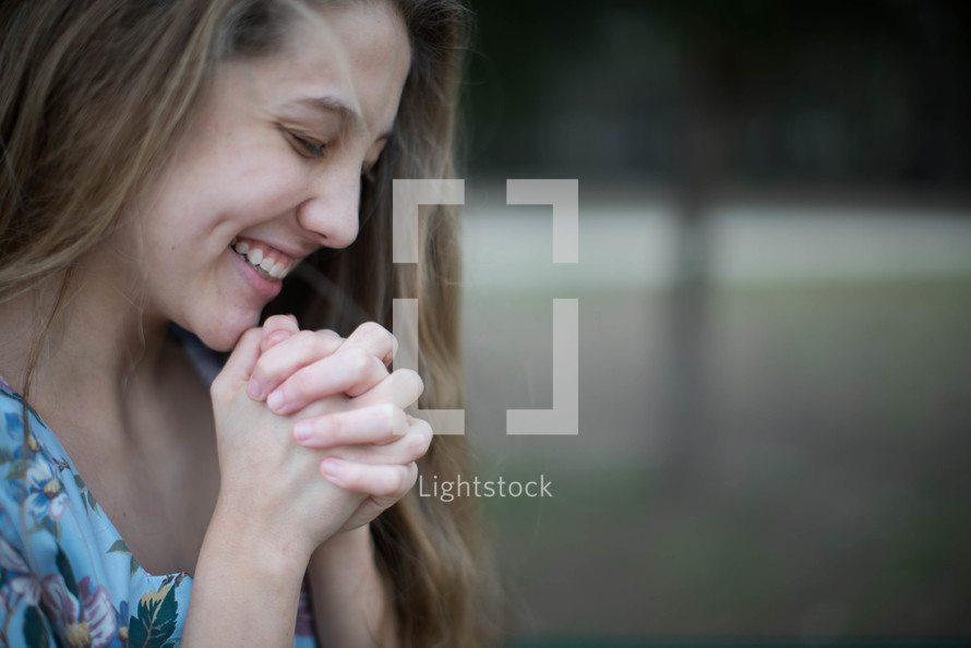 side profile of a young woman in prayer 