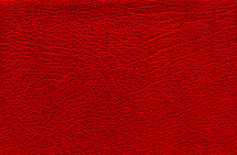 Red background with leather texture. Blank backdrop with a surface of the red skin.