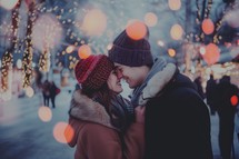 A couple kissing and hugging in a snowy street