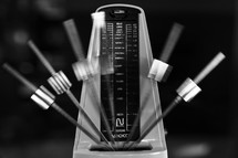 Metronome in motion, in black-and-white.