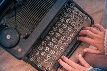 hands on keys on a typewriter 