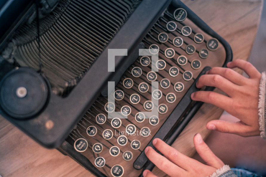 hands on keys on a typewriter 