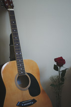 guitar and red rose in a vase 