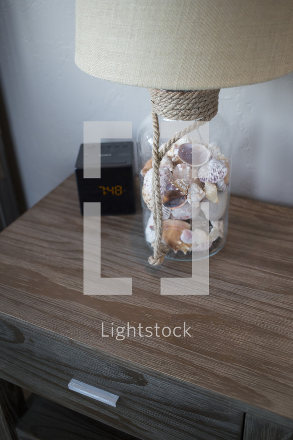 sea shells in a lamp on a night stand 