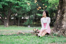 a woman sitting in the grass with a bouquet of flowers lap 