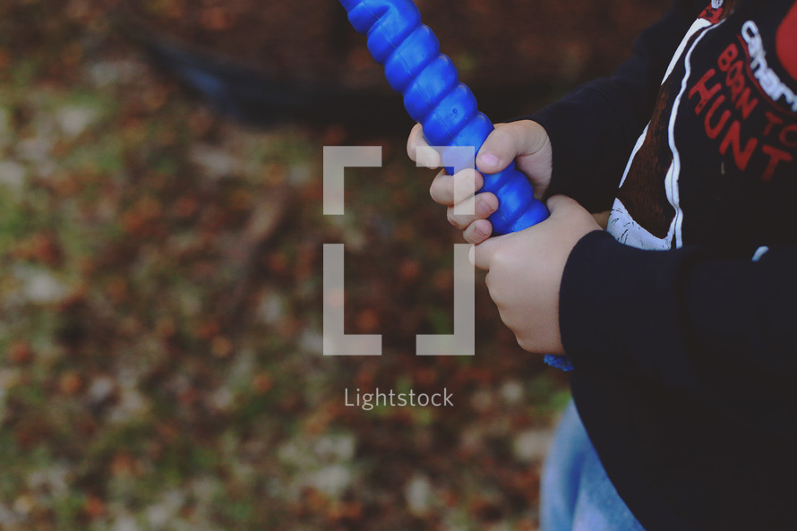 a boy child holding a plastic baseball bat 