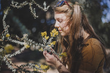 a young girl sniffing yellow flowers