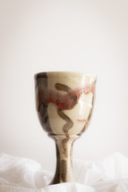 clay chalice on white linen 