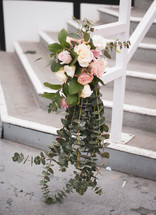 roses and eucalyptus on a railing 