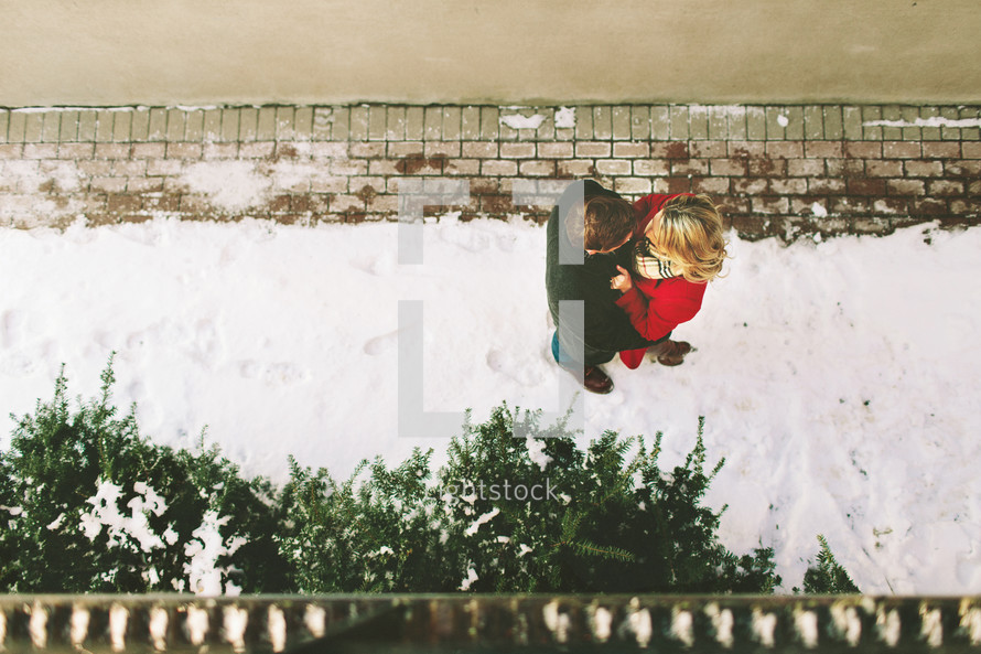 overhead picture of a couple standing in snow 