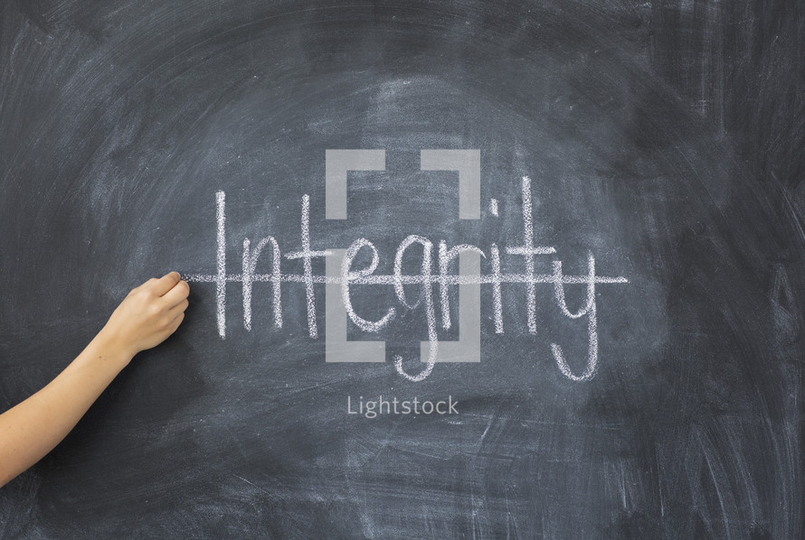 crossing through the word integrity on a chalkboard 