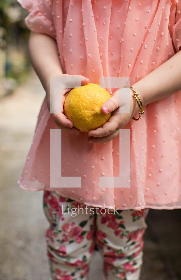 girl holding a lemon 