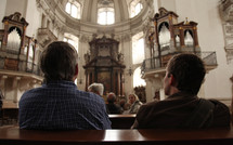 men sitting in pews in a cathedral 