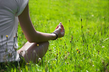 woman meditating sitting in grass 