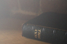 Light shining on a Bible on a table.