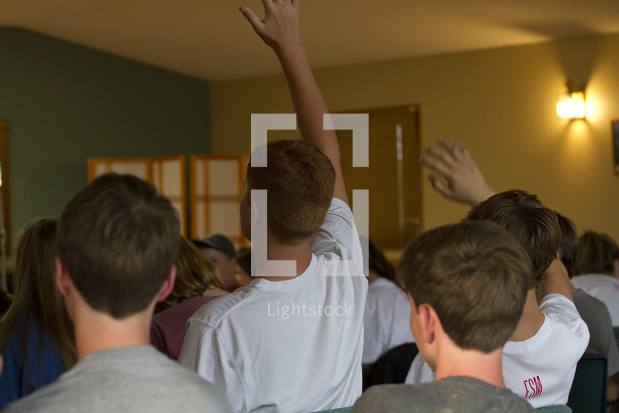 boys with hands raised in a room 
