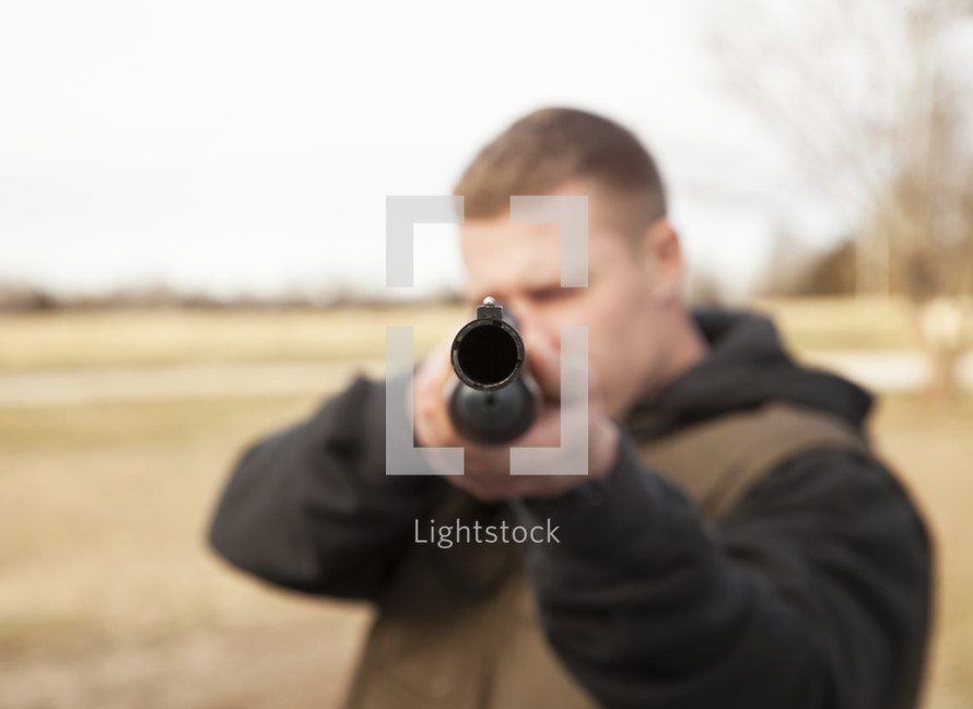 man pointing a rifle 