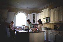 mother and daughters making breakfast in a kitchen 