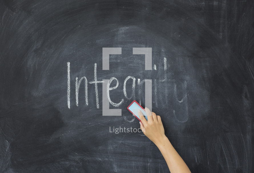 erasing the word Integrity off of a chalkboard 