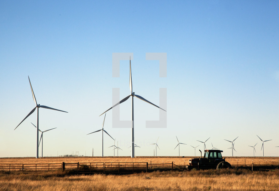 wind turbines and a tractor in a field 