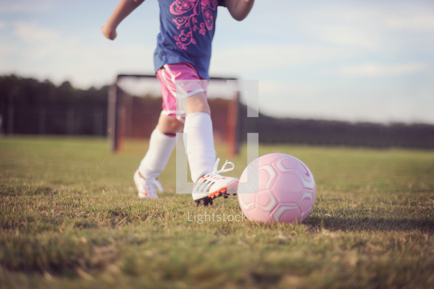 girl child playing soccer 