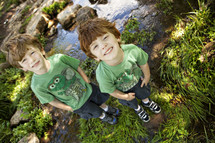 brothers standing in front of a stream