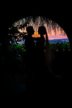 A bride and groom silhouette wedding sunset tunnel