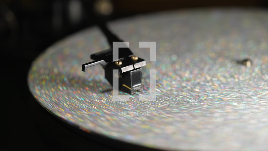 Retro-styled spinning silver record vinyl player. Close up glitter surface. Rotating vintage phonograph. Beautiful picture. Copy space,