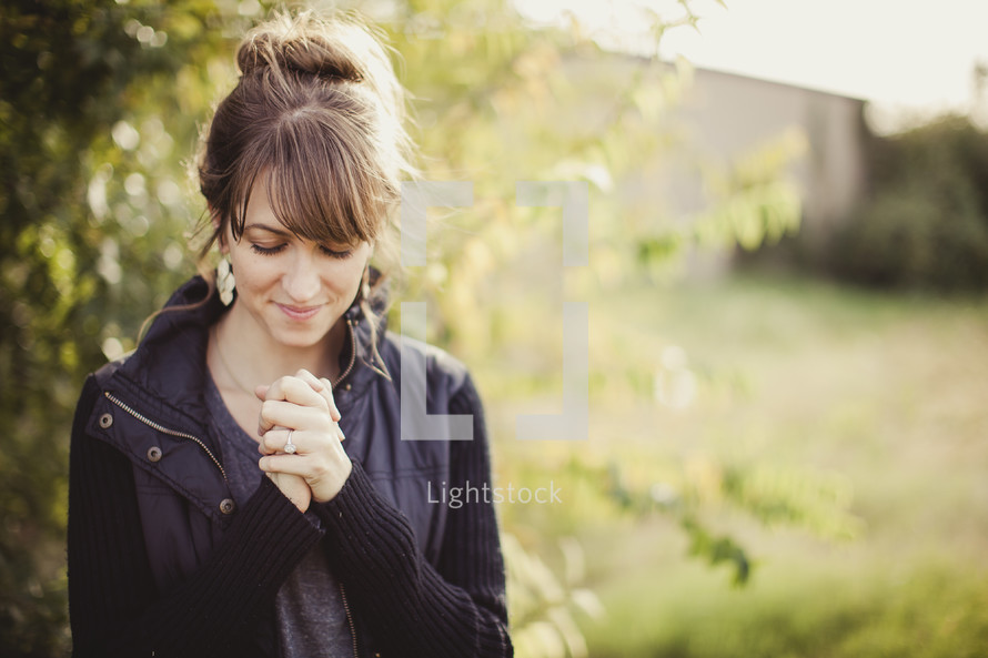 woman with her fingers laced in prayer