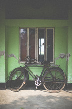 A parked bike against a window 