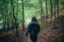 a man hiking through a forest 