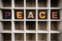 word peace on a wood shelf 