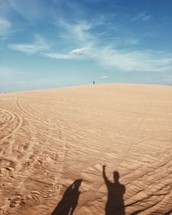 shadows of men on sand 