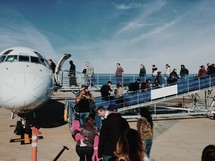 people boarding a small plane 
