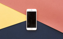 iPhone on a red, yellow, and navy background 