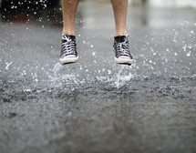 a man jumping in a puddle 
