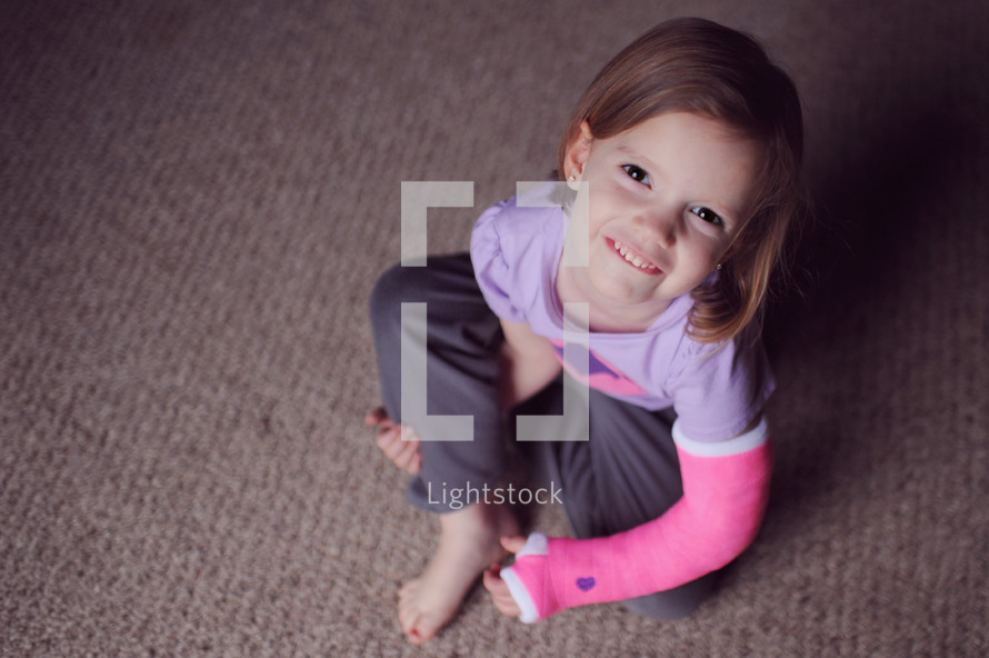 smiling girl child sitting on a floor 