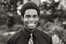 A smiling young man in a shirt and tie black African American 