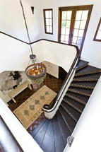 View of staircase, chandelier and foyer from upstairs spanish design decor style
