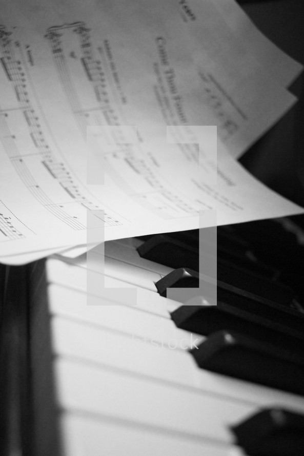 Sheet music laying on a piano keyboard.