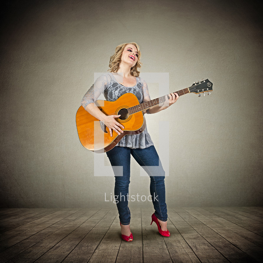 woman playing a guitar on stage