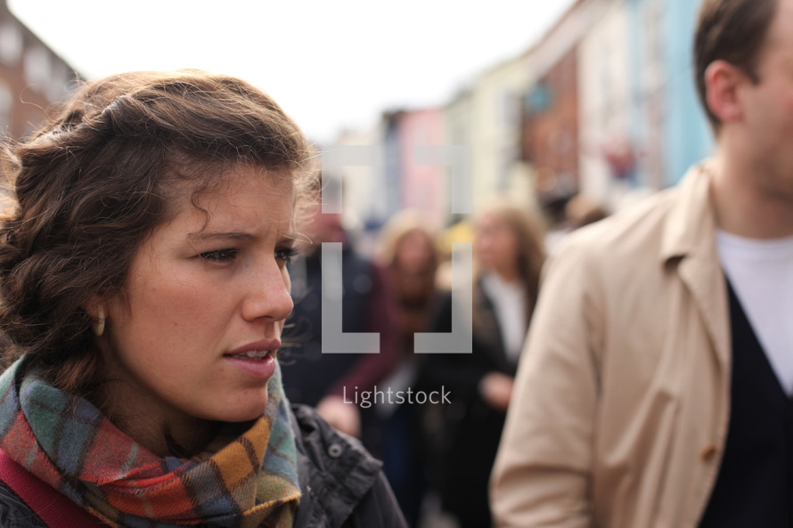 faces of people walking on a crowded sidewalk 