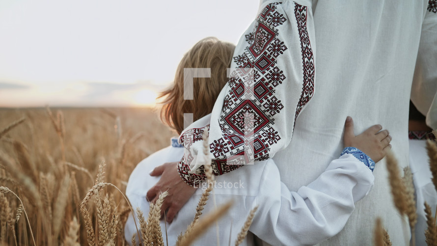 Unrecognizable ukrainian young family in wheat field