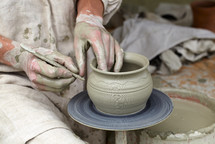 Potter's hands making a pot in a traditional style.