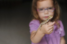 a girl holding a lizard 