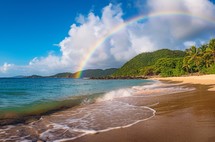 The Caribbean coast glistens after rain, with a vibrant rainbow stretching across the sky, creating a breathtaking and colorful natural scene
