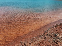 ripples in water over red soil 